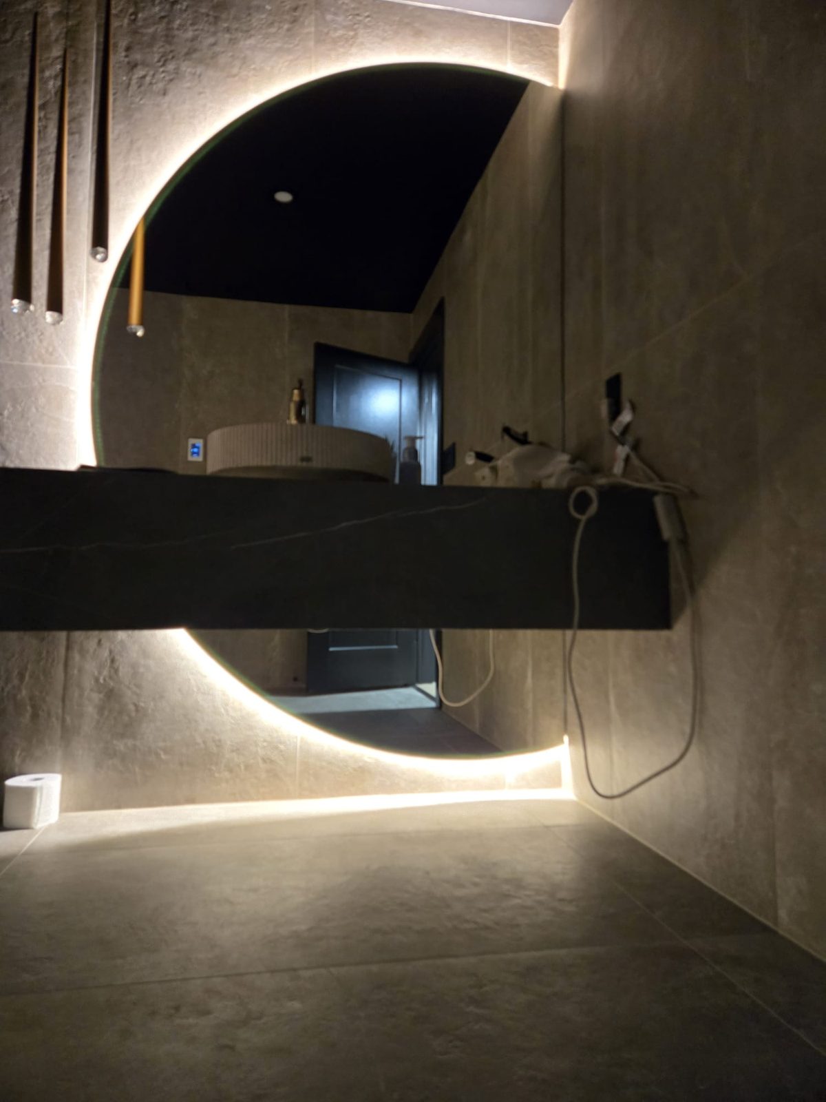 Round backlit mirror over a floating vanity, by HausPower